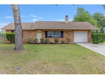 Charming brick home with a well-manicured lawn and attached one-car garage at 2819 Ne 32Nd Pl, Ocala, FL 34479