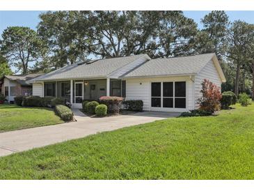 Charming single-story home with a well-manicured lawn and a screened in porch at 36 Gordon Ct, Leesburg, FL 34788