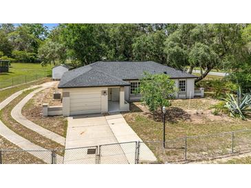 Charming single-story home featuring a well-manicured lawn and attached one car garage at 361 Oak Lane Drive Dr, Ocala, FL 34472