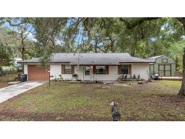 Charming single-story home featuring a cozy front yard and complementary yard shed at 3800 Ne 24Th Ct, Ocala, FL 34479