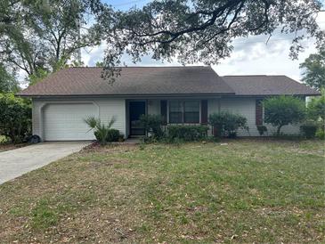 Charming single-story home featuring an attached garage and a well-maintained lawn at 3885 Ne 28Th Ter, Ocala, FL 34479