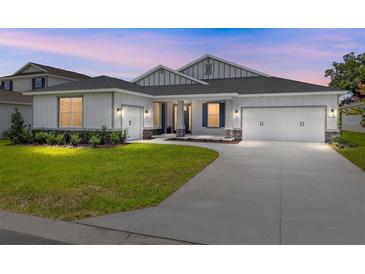 Charming single-Gathering home with a well-manicured lawn, a two-car garage, and stone column accents at 7638 Sw 60Th St, Ocala, FL 34474