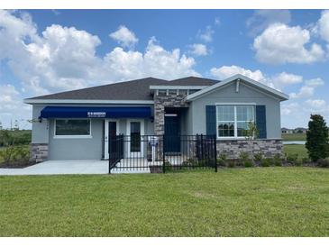 Charming single-story home featuring stone accents and a well-manicured lawn under a bright blue sky at 9354 Sw 60Th Terrace Rd, Ocala, FL 34476