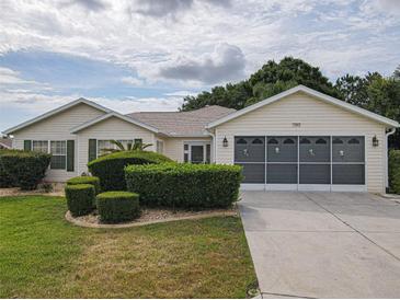 Charming single-story home with a well-manicured lawn and a two-car garage, enhanced by lush landscaping at 13863 Se 85Th Cir, Summerfield, FL 34491