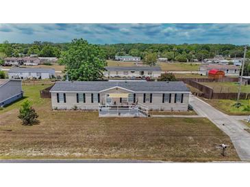 Well-maintained home featuring black shutters, neutral siding, and an inviting front porch at 14276 Se 61St Ave, Summerfield, FL 34491