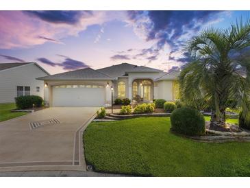 Charming single-story home with a well-manicured lawn and a welcoming two-car garage at 3141 Roswell Rd, The Villages, FL 32162