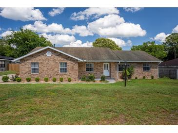 Charming single-story brick home with a well-manicured lawn and blue skies at 3295 Se 56 Ave, Ocala, FL 34480