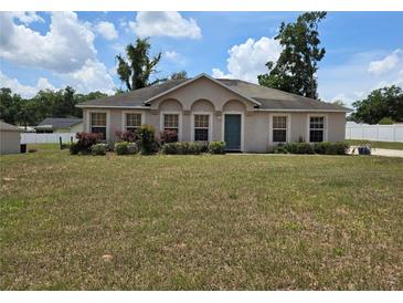 Charming single-story home with a well-manicured lawn, lush landscaping, and a welcoming front entrance at 4460 Sw 44Th St, Ocala, FL 34474
