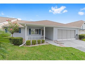 Charming single-story home featuring a covered porch, well-manicured lawn, and attached garage at 8885 Sw 90Th Ave, Ocala, FL 34481