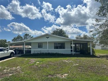 Charming single-story home with a covered carport and a spacious front yard, perfect for relaxing or entertaining outdoors at 10080 Sw 97Th Ct, Ocala, FL 34481