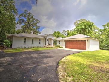 Charming single-story home with a metal roof, attached garage and well-manicured lawn at 1610 Se 22Nd Ave, Ocala, FL 34471