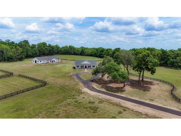 Expansive ranch estate featuring lush pastures, mature trees, and a secondary building for flexible living or storage at 1631 W Hwy 329, Citra, FL 32113