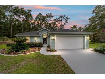 Charming home featuring landscaped front yard and two-car garage, perfect for suburban living at 19028 Sw 101 Pl, Dunnellon, FL 34432