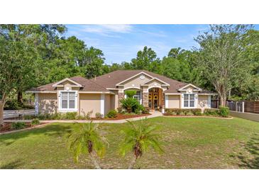 Charming single-story home featuring a well-manicured lawn, mature landscaping, and inviting curb appeal at 5174 Se 41St Ave, Ocala, FL 34480