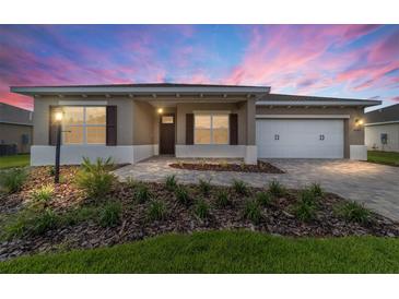Charming single-story home featuring well-manicured landscaping and a brick paver driveway at 10562 Sw 96Th Lane Rd, Ocala, FL 34481