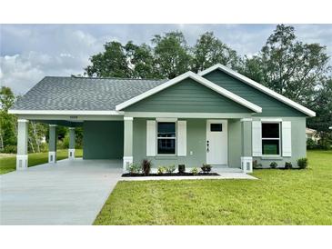 Charming single-story home with a well-maintained lawn and covered carport, showcasing curb appeal at 13319 Sw 106Th Pl, Dunnellon, FL 34432