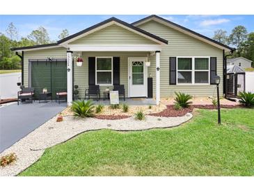 Charming single-story home with a beautifully landscaped front yard and inviting porch at 15324 Sw 40Th Place Rd, Ocala, FL 34481