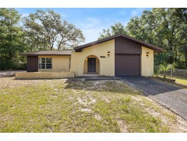 Charming one-story home featuring a stucco exterior, arched entryway, and a one-car garage at 4467 Sw Channel Heights Ct, Dunnellon, FL 34431