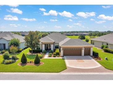 Beautiful single-story home boasts lush landscaping, a three-car garage, and a well-maintained lawn at 6683 Sw 97Th Terrace Rd, Ocala, FL 34481