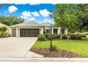Charming single Gathering home with a well maintained lawn, mature tree, and a two-car garage at 8961 Se 130Th Loop, Summerfield, FL 34491