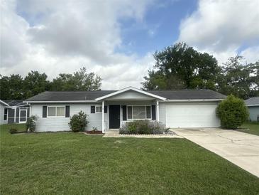 Charming single-story home with well-manicured lawn, attached garage, and inviting entrance at 11248 Sw 76Th Ter, Ocala, FL 34476