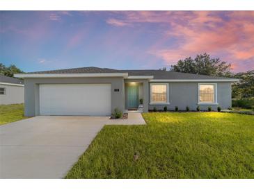 Charming single-story home with a well-manicured lawn, attached garage, and inviting front entrance at 14863 Sw 60Th Ter, Ocala, FL 34473