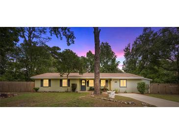 Charming one-story home featuring a well-maintained lawn and mature trees, creating a welcoming curb appeal at 3331 Se 4Th St, Ocala, FL 34471