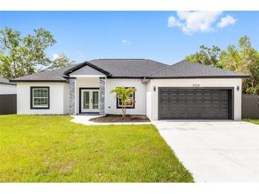 Charming single-story home featuring modern gray accents, black framed windows, and a manicured front lawn at 8456 Se 164Th Pl, Summerfield, FL 34491