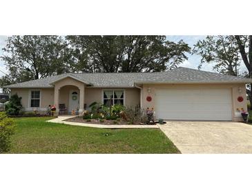 Charming single-story home with a well-maintained lawn and colorful flower beds, offering delightful curb appeal at 106 Pine Trce, Ocala, FL 34472