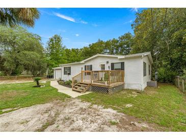 Charming single-story home with a wooden porch and well-maintained lawn at 10671 Ne 152Nd Ln, Fort Mc Coy, FL 32134