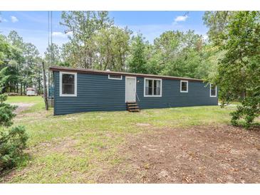 Charming single-story home featuring blue siding, a manicured lawn, and a welcoming front entrance at 16082 Sw 24Th Pl, Ocala, FL 34481