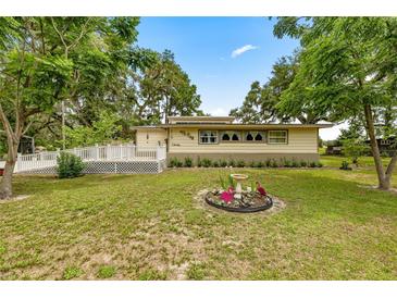 Charming home featuring mature landscaping, a flamingo water feature, and inviting deck at 22535 Sw 117Th St, Dunnellon, FL 34431