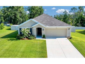 Charming single-story home with a well-manicured lawn, neutral colors, and an attached two-car garage at 7133 Sw 135Th Pl, Ocala, FL 34473