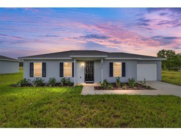 Charming single-story home featuring a well-maintained lawn and inviting front entrance under a colorful dusk sky at 14690 Sw 24Th. Pl, Ocala, FL 34481