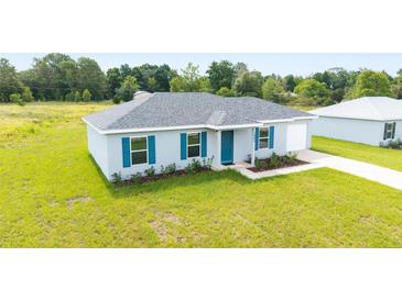 Charming single-story home with a well-manicured lawn, blue shutters, and an attached one-car garage at 14698 Sw 20Th Pl, Ocala, FL 34481
