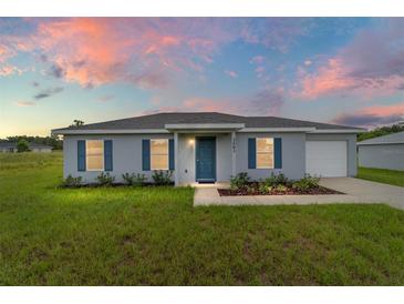 Charming single-story home featuring gray stucco, blue shutters, and a well-manicured lawn at 14893 Sw 23Rd Pl, Ocala, FL 34481