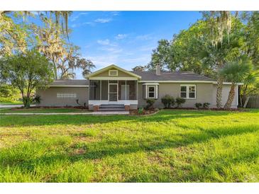 Charming single-story home with mature trees, screened porch, and well-maintained lawn at 4609 Ne 7Th St, Ocala, FL 34470