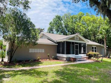 Charming single-story home featuring a screened porch, landscaped front yard, and a brick walkway at 4609 Ne 7Th St, Ocala, FL 34470