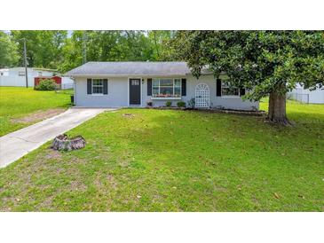 Charming single-story home with a well-maintained front yard and a concrete driveway at 6511 Se 25Th Ave, Ocala, FL 34480