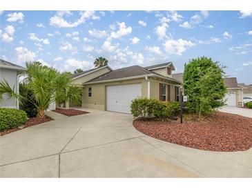 Charming home featuring a two-car garage and meticulously maintained landscaping at 1204 Flamingo Pl, The Villages, FL 32162