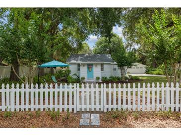 Charming home featuring a well-manicured lawn and inviting white picket fence at 12335 Se 130Th Ct, Ocklawaha, FL 32179