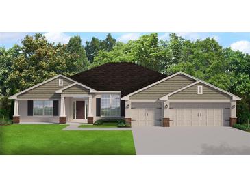 Charming single-story home featuring a manicured lawn, attached three car garage and welcoming front entryway at 13977 Sw 81St St, Dunnellon, FL 34432