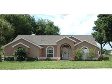 Charming single-story home featuring a well-maintained lawn, arched entryway and front door wreath at 14126 Greater Pines Blvd, Clermont, FL 34711