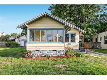 Charming single-story home with light yellow siding, a large picture window, and a well-manicured lawn at 1434 Se Silver Springs Pl, Ocala, FL 34471