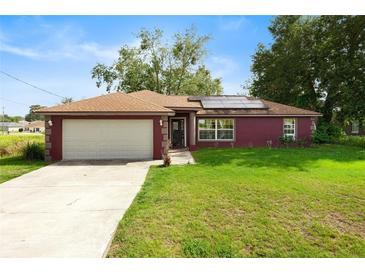 Charming single-story home with a well-manicured lawn, attached garage, and inviting front entrance at 32 Dogwood Drive Loop, Ocala, FL 34472