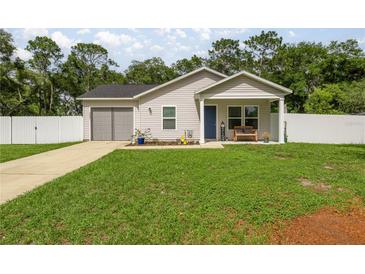 Charming single-story home with a well-manicured lawn and inviting front porch at 5063 Se 168Th Ter, Ocklawaha, FL 32179