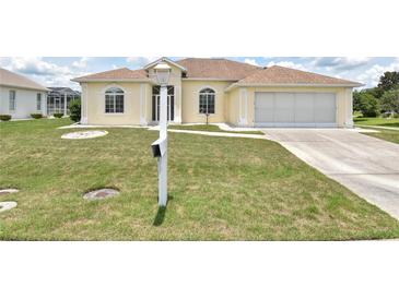 Charming home featuring a well-maintained lawn, inviting curb appeal, and an attached two-car garage at 5551 Nw 25Th Loop, Ocala, FL 34482