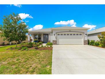 Charming single-Gathering home features a manicured lawn, stone accents, and a two-car garage at 7891 Sw 89Th Cir, Ocala, FL 34481