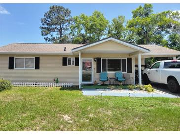 Charming single-story home with a covered porch, car port and well-maintained lawn at 8368 Sw 105Th Pl, Ocala, FL 34481