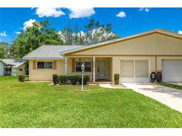 Charming single-story home with a well-manicured lawn, covered porch, and attached garage at 8625 Sw 94Th Ln # A, Ocala, FL 34481
